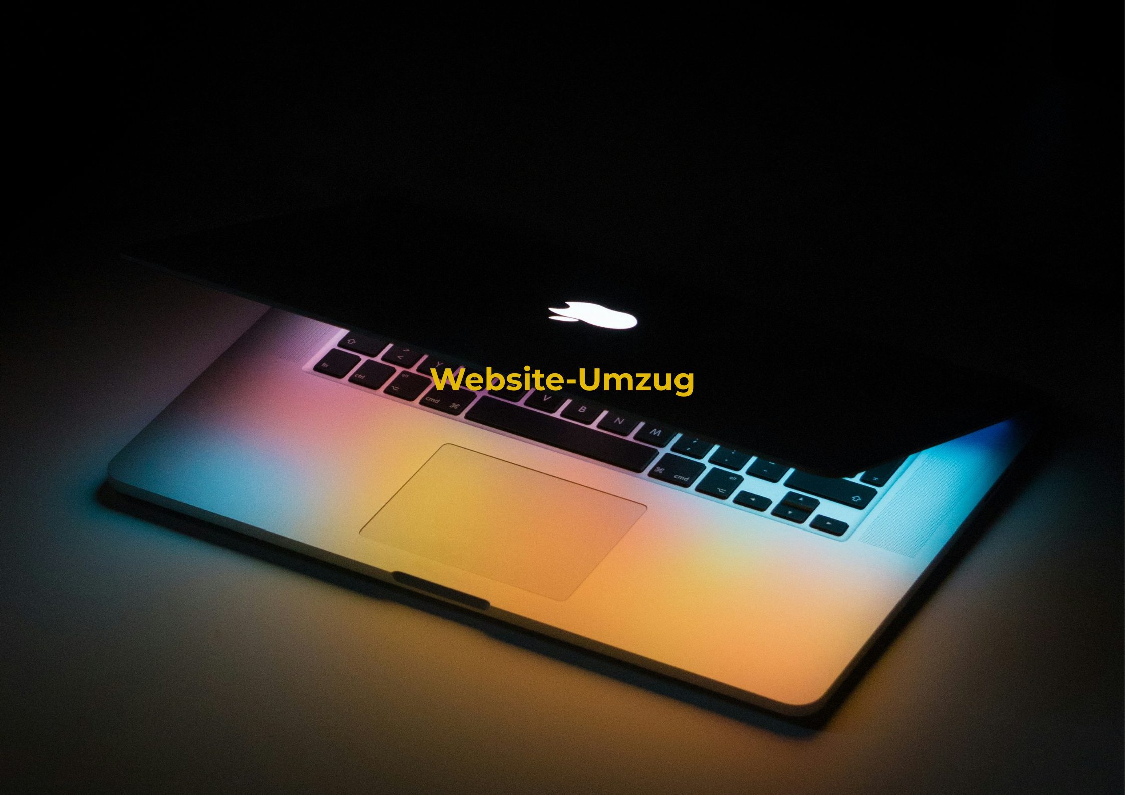 ein Macbook in einer dunklen Umgebung. Es ist leicht aufgeklappt und wirft farbiges Licht vom Bildschirm ab. Auf dem Bild steht Website-Umzug.
